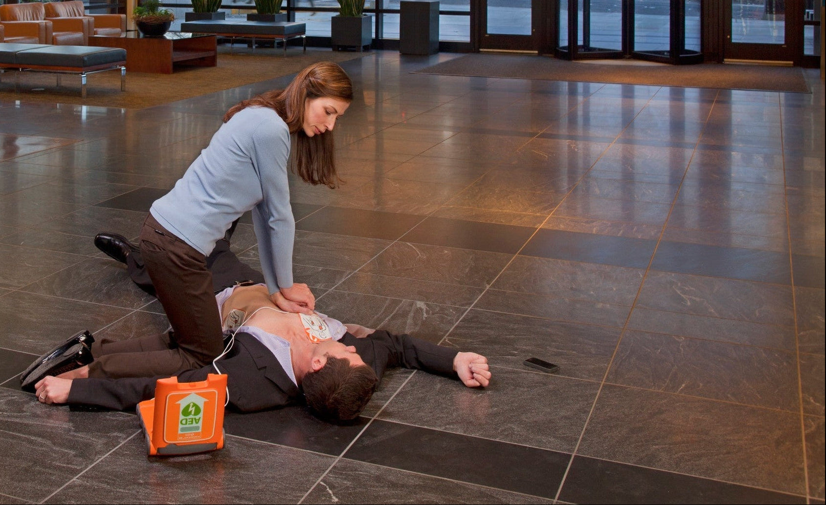 Person performing CPR in public with a Powerheart G5 AED.
